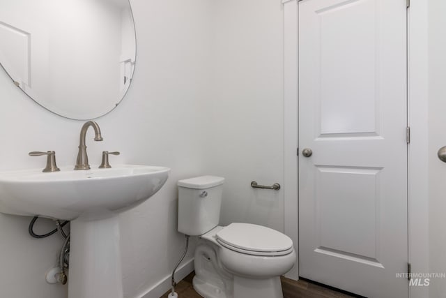 bathroom with sink, toilet, and hardwood / wood-style flooring