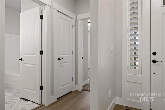 entryway with baseboards and wood finished floors