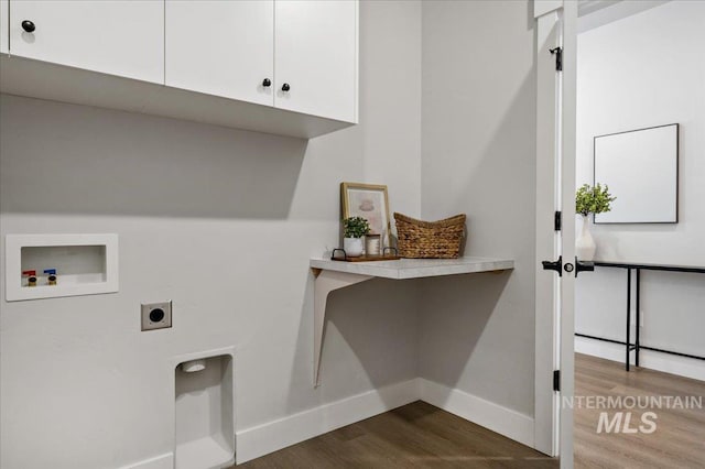 laundry room featuring baseboards, hookup for a washing machine, dark wood-style floors, cabinet space, and electric dryer hookup