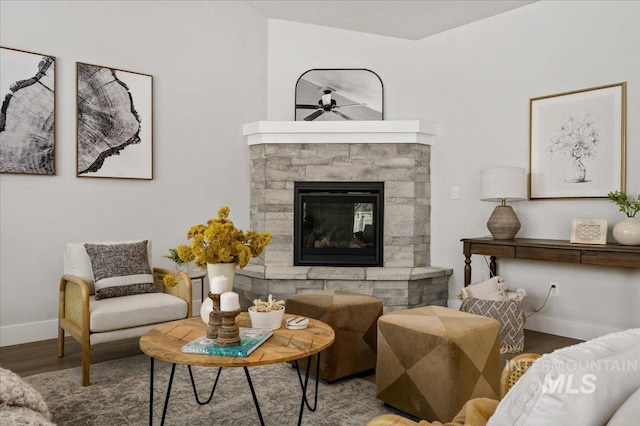 living room with wood finished floors, a fireplace, and baseboards