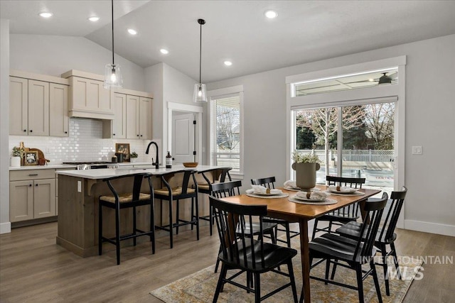 dining area featuring lofted ceiling, recessed lighting, baseboards, and light wood finished floors