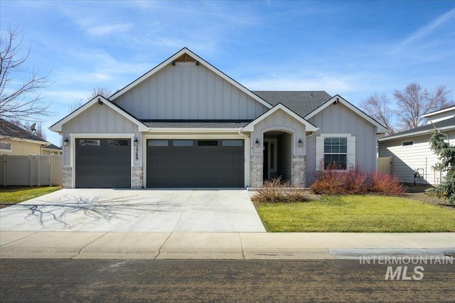 view of front of property featuring fence, driveway, an attached garage, a front lawn, and board and batten siding