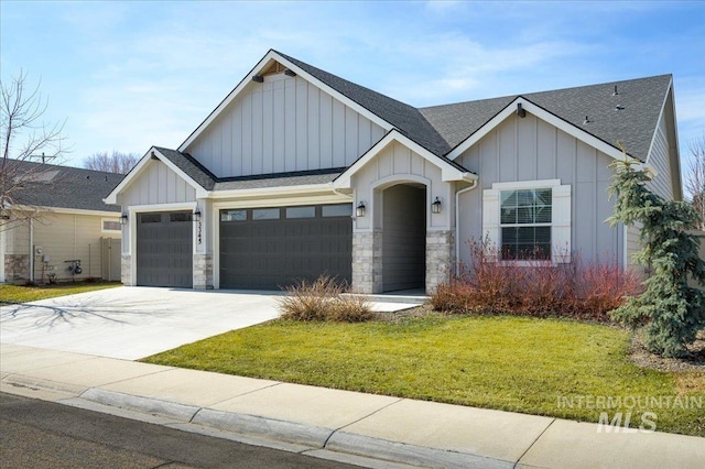 view of front of home with board and batten siding, concrete driveway, a front yard, roof with shingles, and a garage