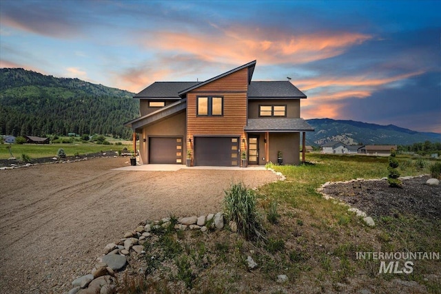 15 Alder Creek Ln, Garden Valley, ID 83622 - contemporary house with a mountain view, dirt driveway, a garage, and a shingled roof