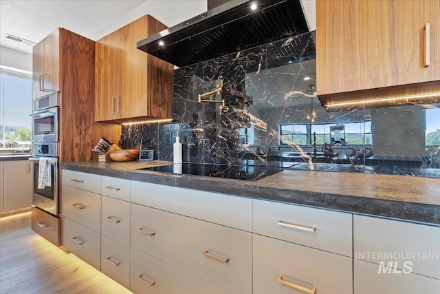 15 Alder Creek Ln, Garden Valley, ID 83622 - kitchen with ventilation hood, oven, black electric stovetop, backsplash, and dark countertops