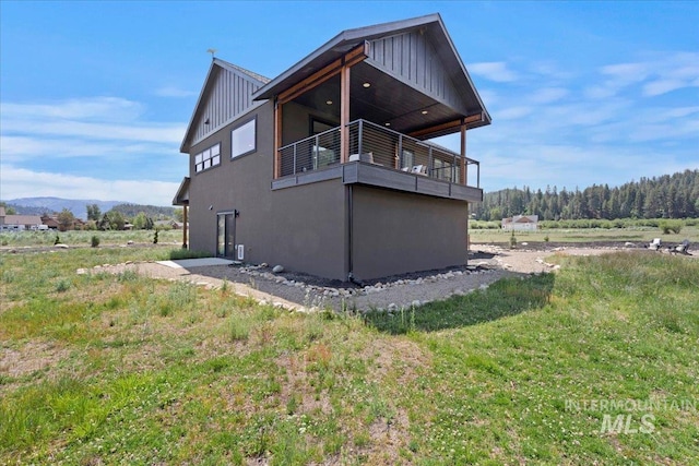 15 Alder Creek Ln, Garden Valley, ID 83622 - view of home's exterior with board and batten siding, a balcony, and a mountain view