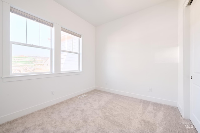 carpeted spare room with baseboards and visible vents