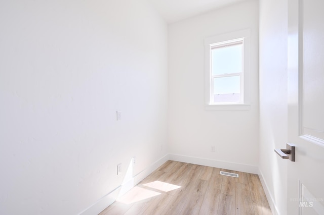 empty room featuring visible vents, light wood-style flooring, and baseboards