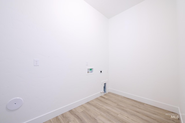 clothes washing area featuring baseboards, light wood-style floors, laundry area, electric dryer hookup, and hookup for a washing machine