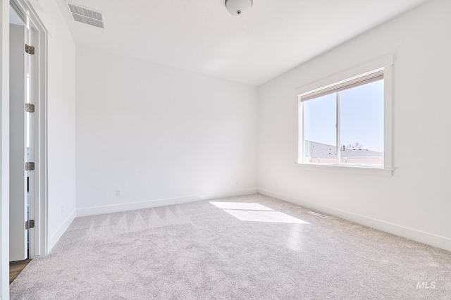 carpeted empty room with visible vents and baseboards