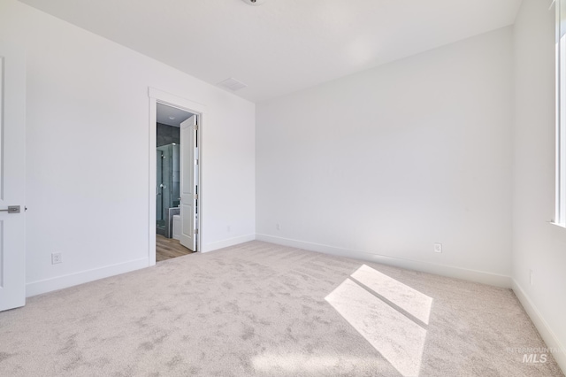 unfurnished room with carpet flooring, visible vents, and baseboards