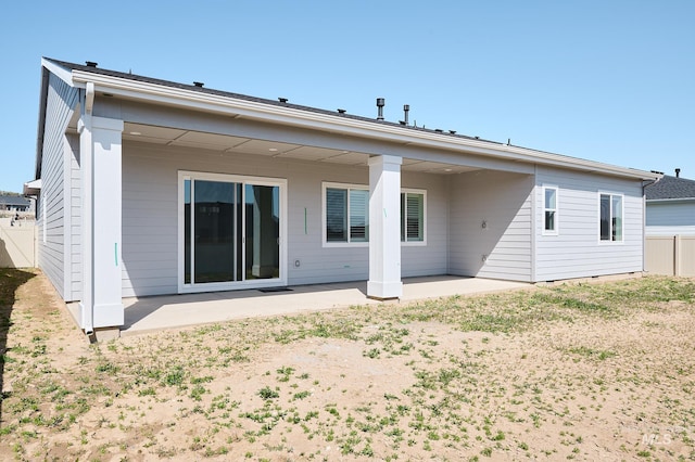 back of property featuring fence and a patio