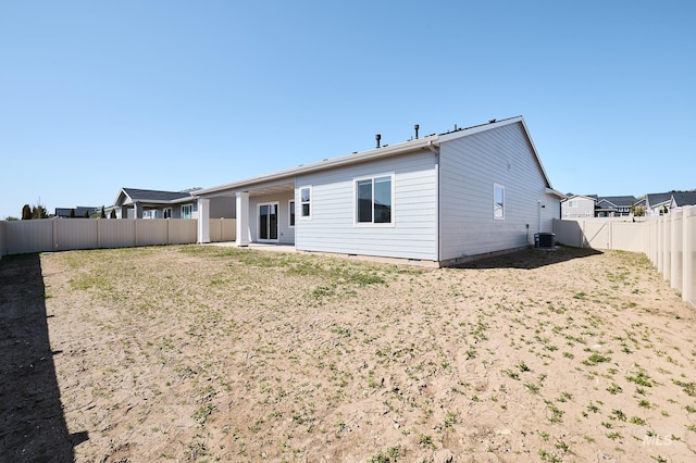back of house featuring central AC unit and a fenced backyard