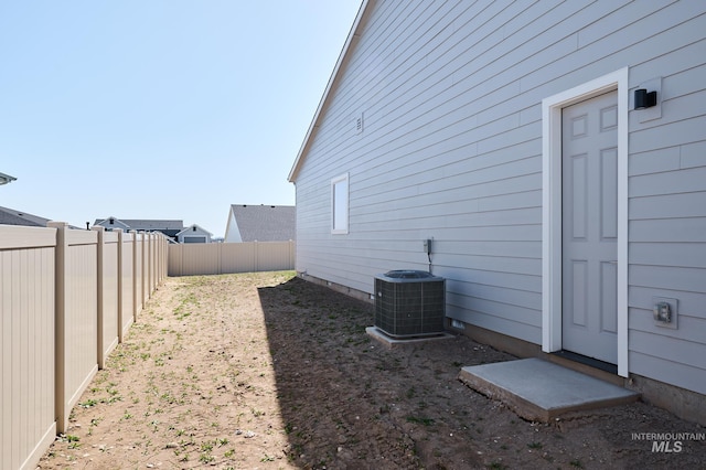 view of side of home featuring a fenced backyard and cooling unit