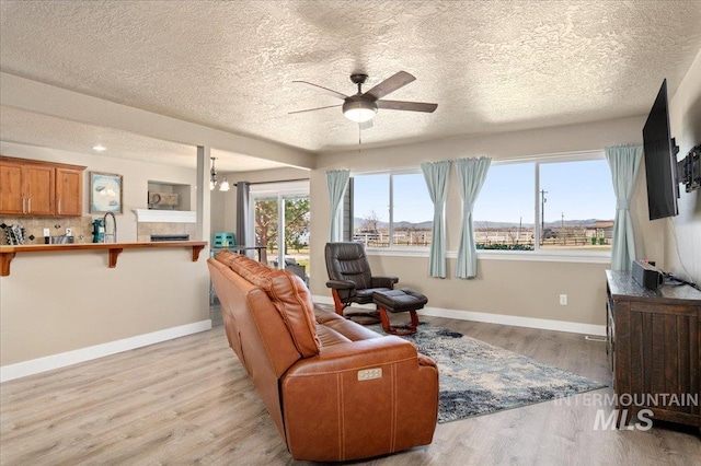 1375 Ross Rd, Weiser, ID 83672 - living area with ceiling fan, a textured ceiling, light wood finished floors, and a tiled fireplace