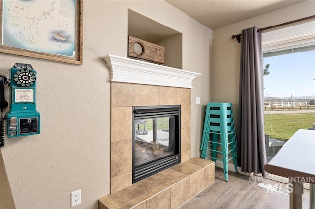 1375 Ross Rd, Weiser, ID 83672 - detailed view of wood finished floors, a tiled fireplace, and a textured wall