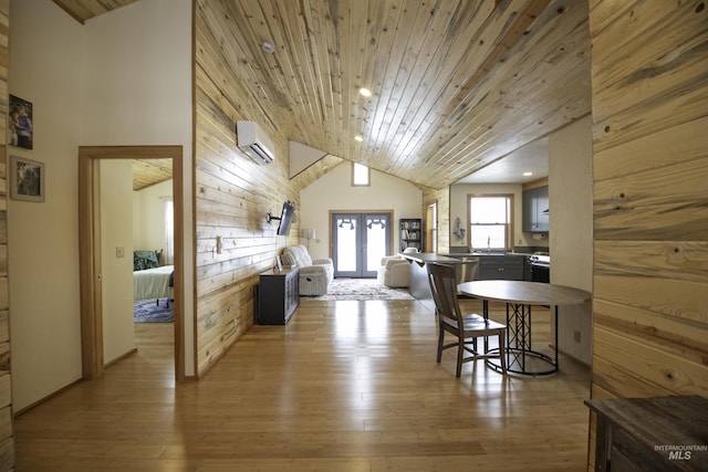 dining area featuring french doors, wooden ceiling, wood walls, light wood-style floors, and a wall mounted AC