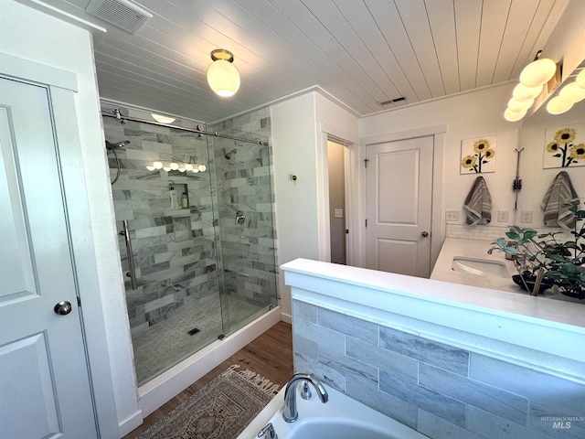 4446 S Carina Way, Meridian, ID 83642 - bathroom with a stall shower, a garden tub, wood finished floors, and double vanity