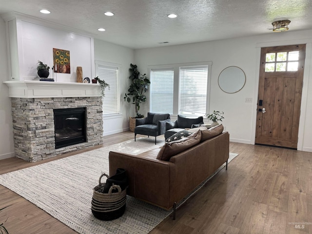 4446 S Carina Way, Meridian, ID 83642 - living area with a fireplace, wood finished floors, baseboards, a textured ceiling, and recessed lighting