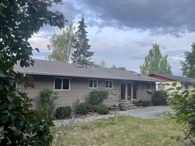 833 N Cleveland St, Moscow, ID 83843 - view of front of house featuring a front yard, entry steps, a shingled roof, a patio area, and a chimney