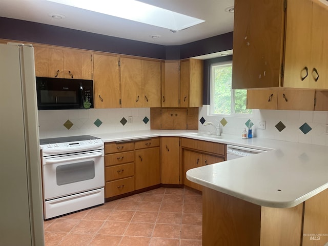 833 N Cleveland St, Moscow, ID 83843 - kitchen featuring white appliances, a skylight, light countertops, a peninsula, and decorative backsplash