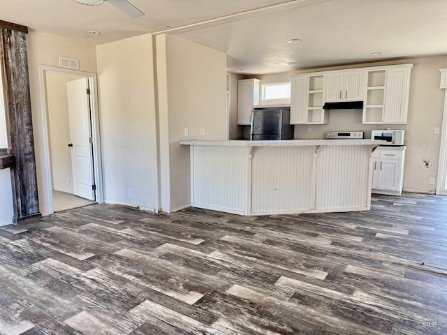 150 Sunset Dr N, Hagerman, ID 83332 - kitchen featuring white microwave, freestanding refrigerator, dark wood finished floors, open shelves, and stove