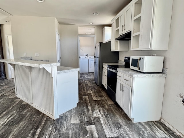 150 Sunset Dr N, Hagerman, ID 83332 - kitchen featuring white microwave, black / electric stove, washer and clothes dryer, under cabinet range hood, and a kitchen breakfast bar