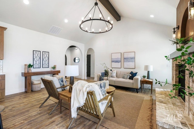 968 Gregory Way, Twin Falls, ID 83301 - living room featuring arched walkways, beam ceiling, wood finished floors, high vaulted ceiling, and a chandelier