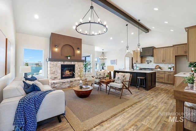 968 Gregory Way, Twin Falls, ID 83301 - living area with a chandelier, light wood-type flooring, beamed ceiling, a glass covered fireplace, and high vaulted ceiling
