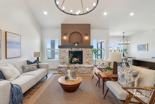 968 Gregory Way, Twin Falls, ID 83301 - living room featuring a chandelier, recessed lighting, a lit fireplace, vaulted ceiling, and wood finished floors