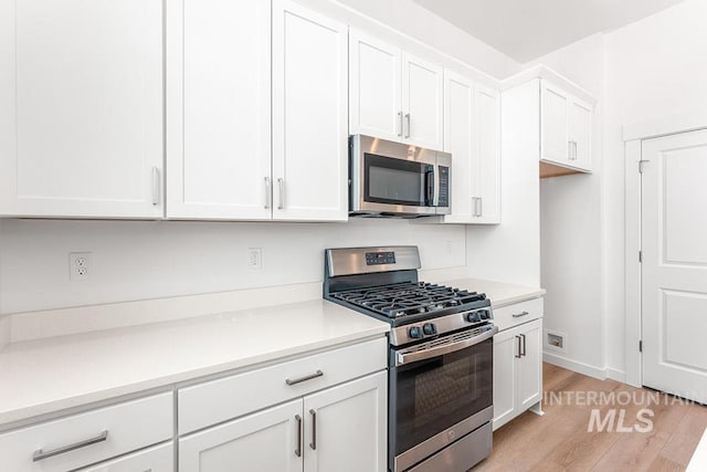 1609 N Impreza Ln Lot 24/1, Boise, ID 83713 - kitchen featuring stainless steel appliances, light wood finished floors, white cabinetry, light countertops, and baseboards