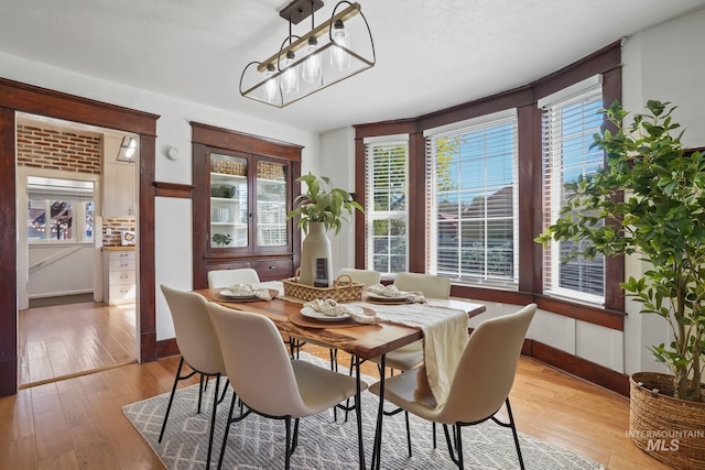 dining room featuring a chandelier, light wood-style flooring, and baseboards