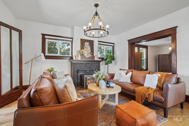 living area featuring baseboards, ornamental molding, wood finished floors, and a notable chandelier