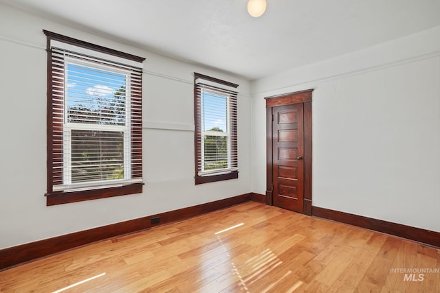 empty room with baseboards and light wood-style floors