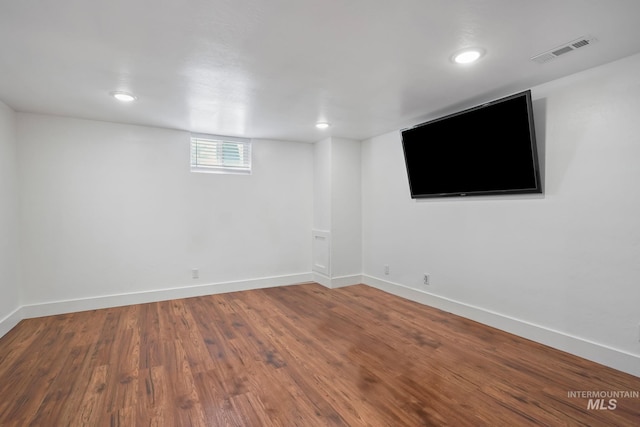 basement with recessed lighting, wood finished floors, visible vents, and baseboards