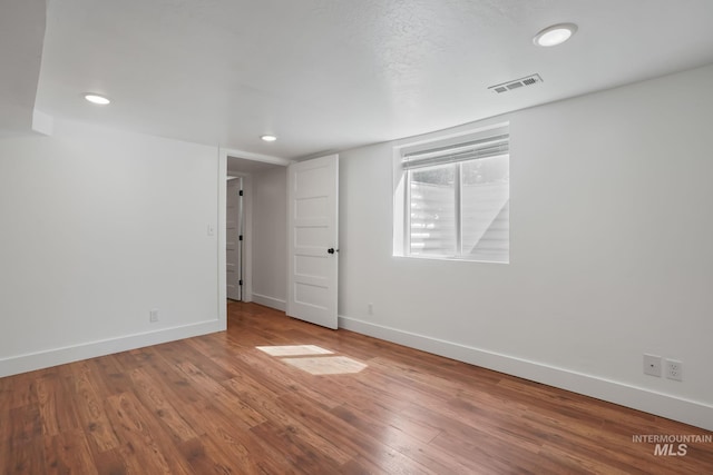 empty room featuring recessed lighting, visible vents, baseboards, and wood finished floors