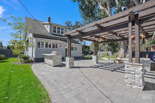 exterior space with exterior kitchen, fence, and a pergola