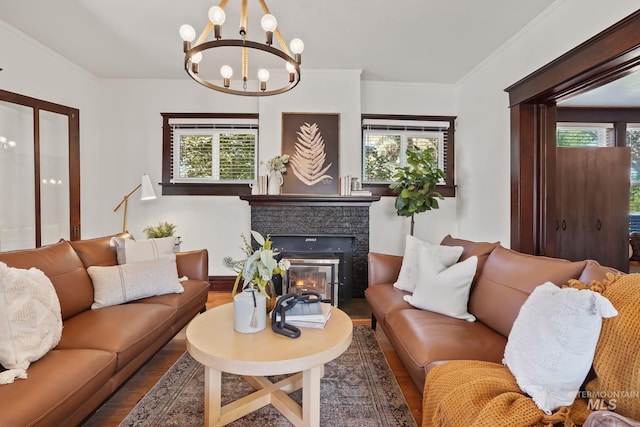 living area with plenty of natural light, ornamental molding, wood finished floors, and a glass covered fireplace