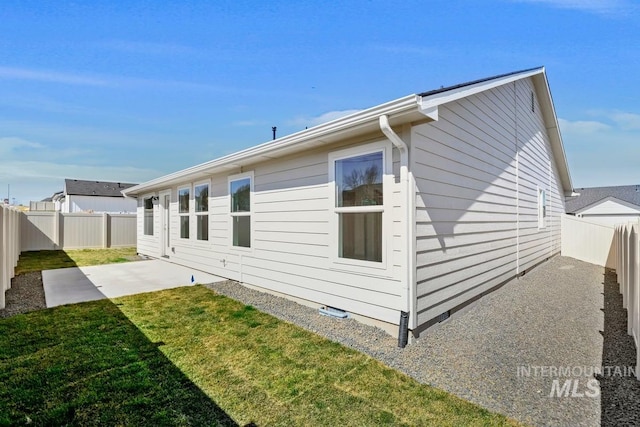 rear view of house featuring a fenced backyard, a patio area, and a yard