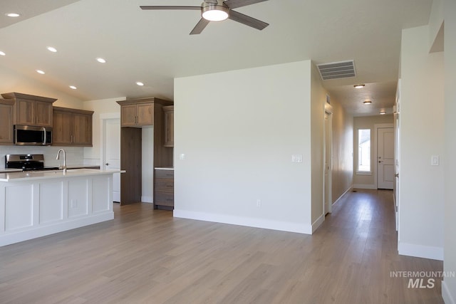 kitchen featuring decorative backsplash, stainless steel appliances, visible vents, light wood-style floors, and ceiling fan