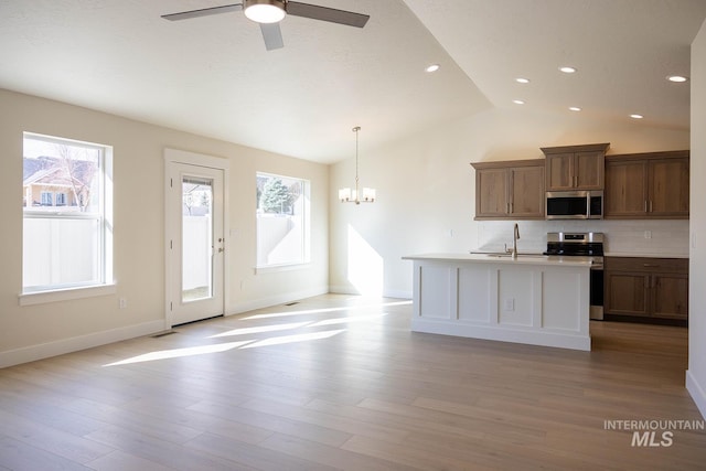 kitchen with a sink, plenty of natural light, light wood-type flooring, and appliances with stainless steel finishes