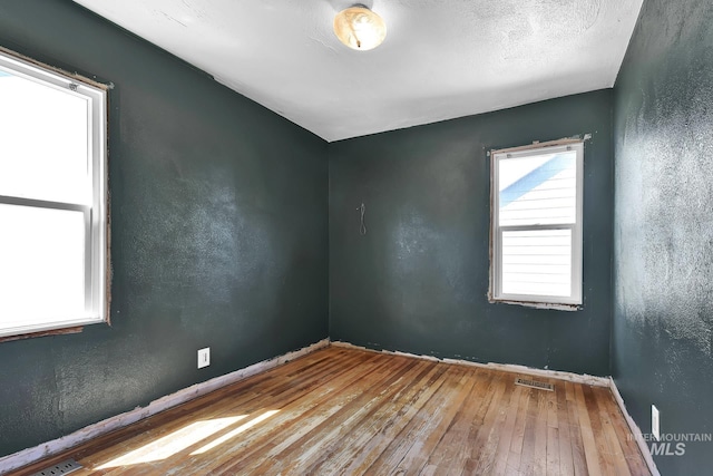 1219 N Indiana, Caldwell, ID 83605 - spare room featuring baseboards, hardwood / wood-style floors, and visible vents