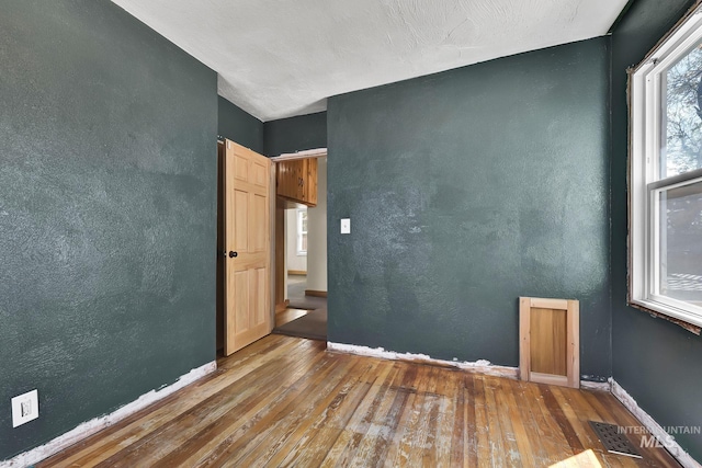 1219 N Indiana, Caldwell, ID 83605 - spare room featuring wood-type flooring, baseboards, and visible vents
