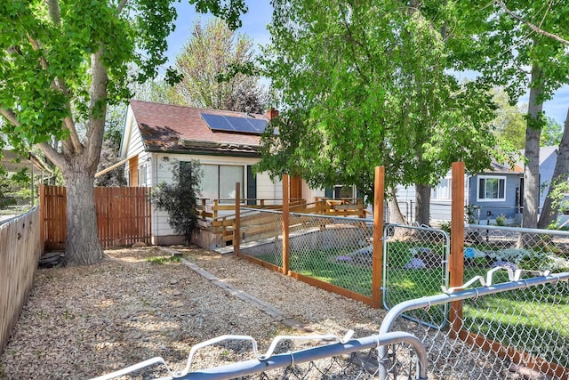 1219 N Indiana, Caldwell, ID 83605 - rear view of property featuring solar panels, a fenced backyard, roof with shingles, and a chimney