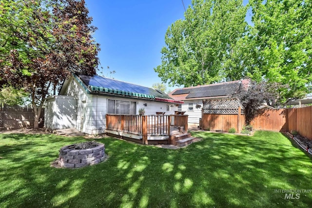 1219 N Indiana, Caldwell, ID 83605 - rear view of property featuring a fenced backyard, an outdoor fire pit, a wooden deck, and a yard