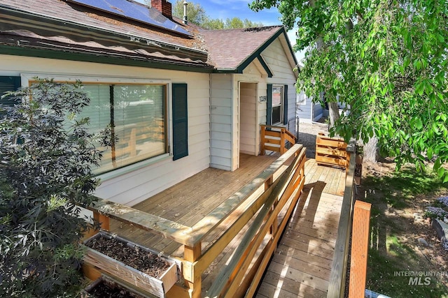 1219 N Indiana, Caldwell, ID 83605 - view of side of home with a shingled roof, roof mounted solar panels, a chimney, and a deck