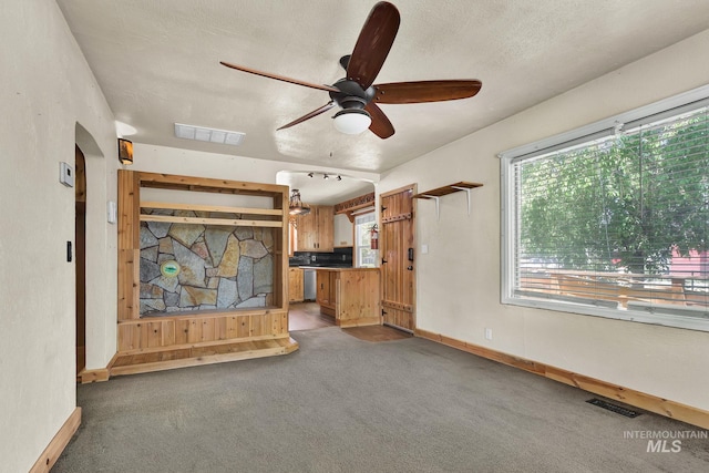 1219 N Indiana, Caldwell, ID 83605 - unfurnished living room with ceiling fan, light colored carpet, a healthy amount of sunlight, and visible vents