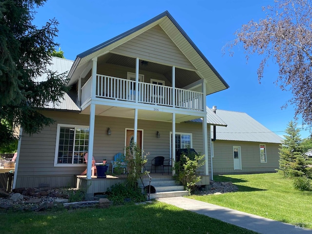 view of front of house featuring a balcony and a front lawn