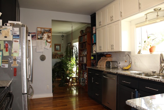 kitchen with dark hardwood / wood-style floors, stainless steel appliances, backsplash, white cabinetry, and sink