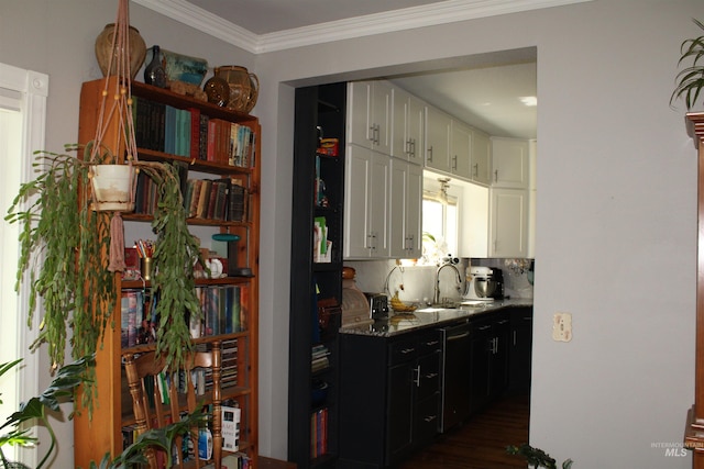 kitchen with dark wood-type flooring, light stone counters, backsplash, sink, and white cabinets